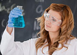 Beautiful female scientist looking at a flask