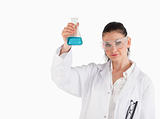 Dark-haired scientist holding a blue flask