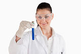 Smiling female scientist looking at a blue test tube