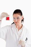 Dark-haired scientist conducting an experiment looking at a red 