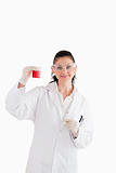 Dark-haired scientist looking at the camera while holding a red 