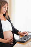 Pretty pregnant woman working with a computer