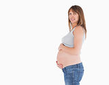 Side view of a beautiful pregnant woman caressing her belly whil