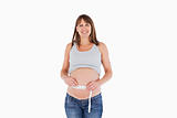 Charming pregnant woman measuring her belly while standing
