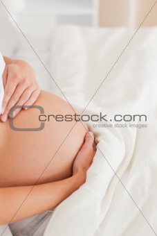 Close-up of a young pregnant woman lying on a bed