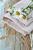 bouquet of daisies on the linen bag  on a wooden table rustic still life