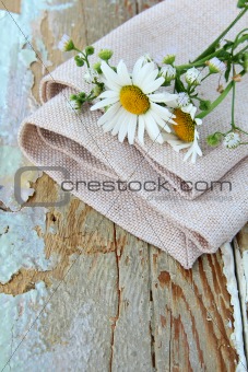 bouquet of daisies on the linen bag on a wooden table rustic still life