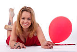 mature woman lying, holding a ballon, isolated on white, studio shot