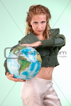 Pretty blonde woman holding globe of world, studio shot