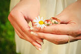 Wedding rings on hands of the bride on a camoline