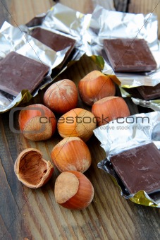 tasty chocolate with hazelnuts on wooden table