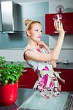 Housewife with clean glass in interior of kitchen