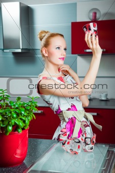 Housewife with clean glass in interior of kitchen