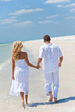 Happy Young Couple Running or Walking Holding Hands on Tropical 
