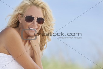 Beautiful Blond Woman in White Dress and Sunglasses At Beach