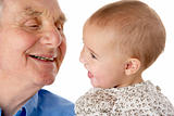 Portrait of grandfather and granddaughter, smiling at each other