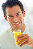 Mid Adult Man Smiling At The Camera And Drinking Orange Juice