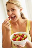 Young Woman Eating A Bowl Of Fruit