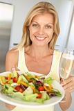 Mid Adult Woman Holding A Wine Glass And Fresh Salad