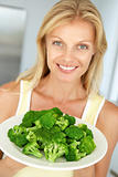 Mid Adult Woman Holding A Plate Of Broccoli