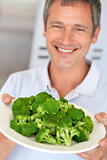 Middle Aged Man Holding A Plate Of Broccoli
