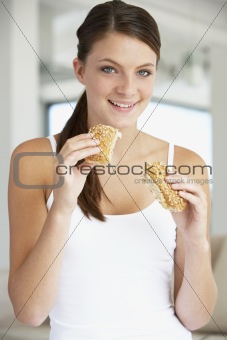 Young Woman Eating Brown Bread Roll