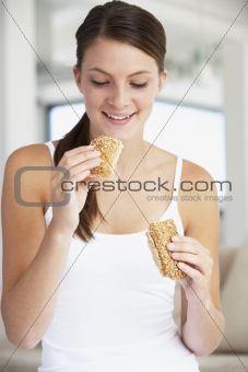 Young Woman Eating Brown Bread Roll