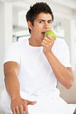 Young Man Eating A Green Apple