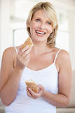 Mid Adult Woman Eating Fresh Brown Bread Roll
