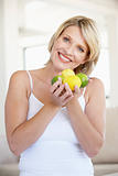 Mid Adult Woman Holding Fresh Fruit And Smiling At The Camera