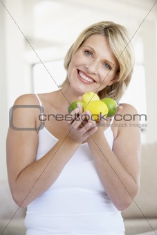 Mid Adult Woman Holding Fresh Fruit And Smiling At The Camera