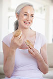 Senior Woman Eating Brown Bread Roll