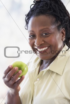 Senior Woman Eating Green Apple And Smiling At The Camera