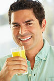 Mid Adult Man Holding A Glass Of Fresh Orange Juice, Smiling At 