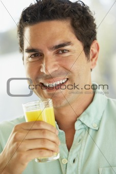 Mid Adult Man Holding A Glass Of Fresh Orange Juice, Smiling At 