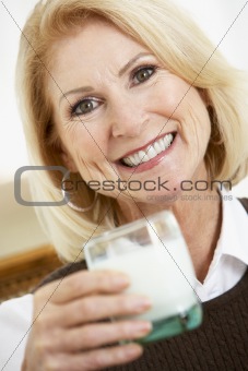 Senior Woman Holding A Glass Of Milk, Smiling At The Camera