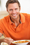 Middle Aged Man Eating Soup, Smiling At The Camera