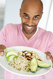Middle Aged Man Holding Out A Plate With Healthy Foods