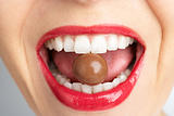 Close-Up Of Woman's Mouth Biting On Chocolate