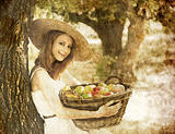 Beautiful redhead girl with fruits in basket at garden.