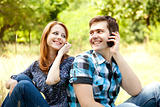 Couple calling by mobile phone at outdoor in summer time.