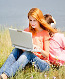Two girlfriends at countryside with laptop and computer.