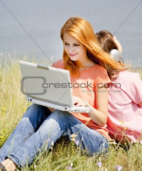 Two girlfriends at countryside with laptop and computer.
