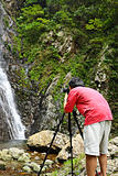photographer taking picture of waterfall
