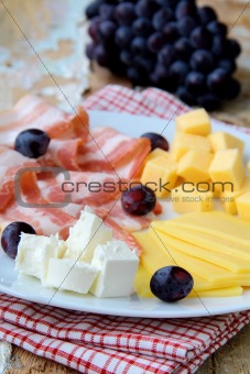 Snack cheese plate with grapes  and smoked bacon