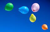 Toy balloons fly in the sky.