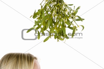Woman standing under bunch of mistletoe