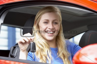Teenage Girl Sitting In Car, Holding Car Keys And Smiling At The