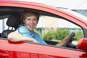 Teenage Boy Sitting In Car, Smiling At The Camera