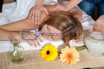 Beautiful young woman having a massage in wellness centre - girl